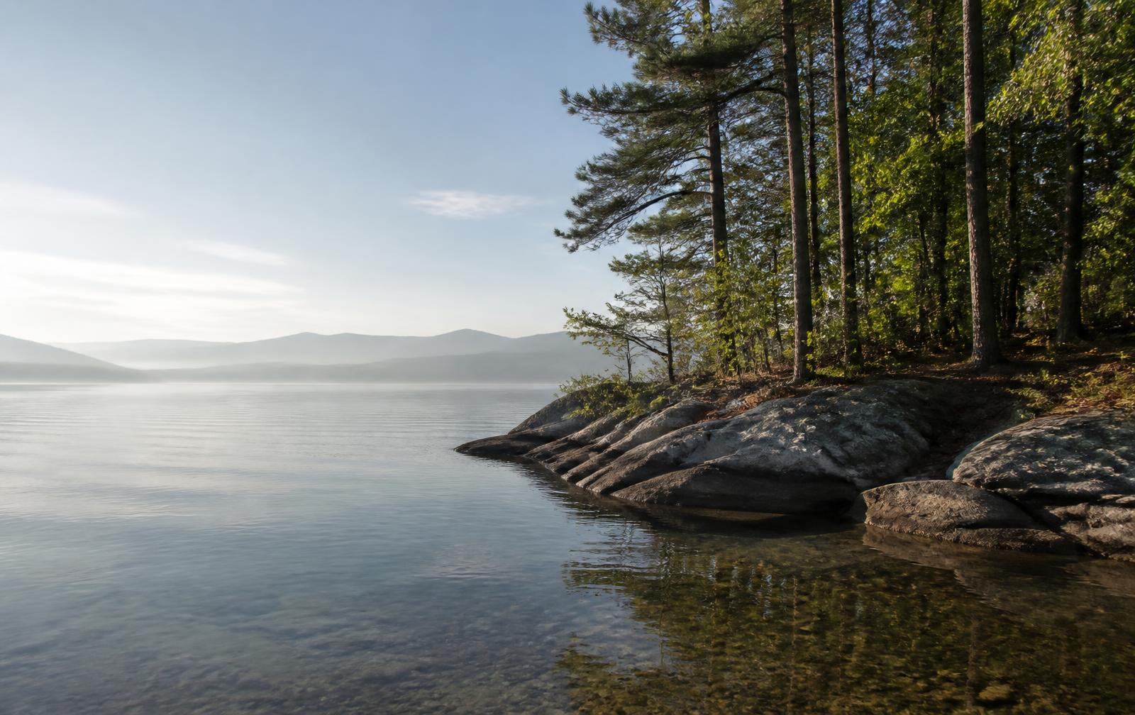 Clear lake water meeting a granite and pine shoreline in the Upstate